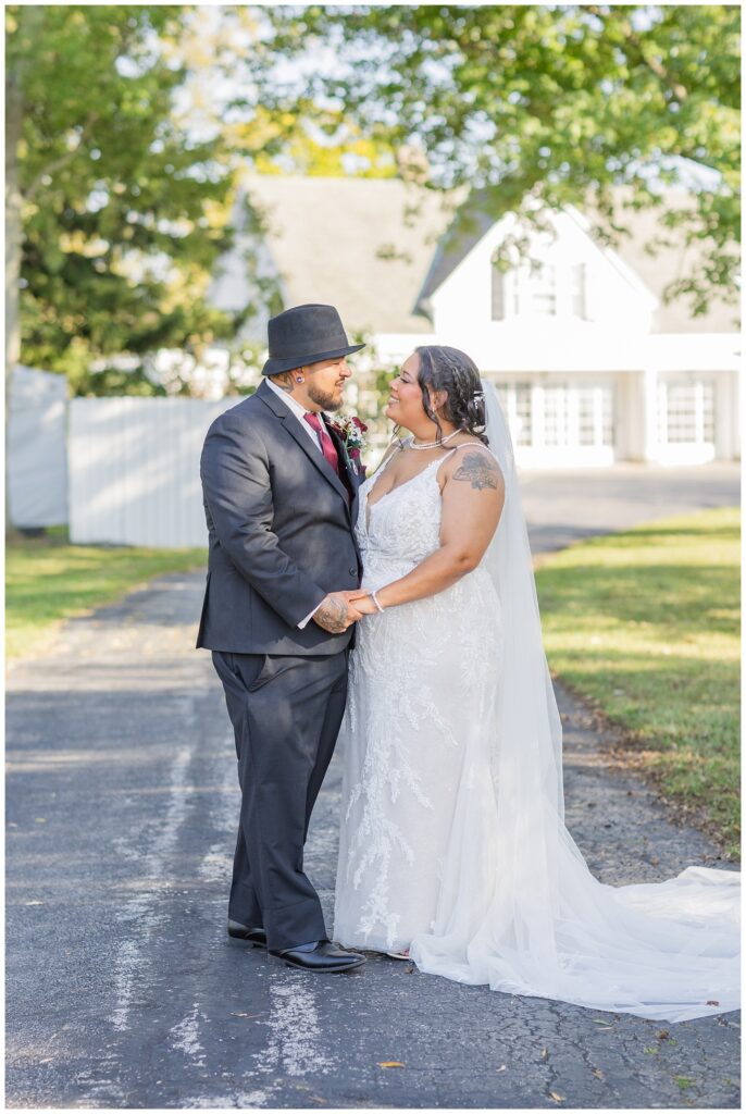 wedding couple holding hands and posing on the driveway of the Christy House