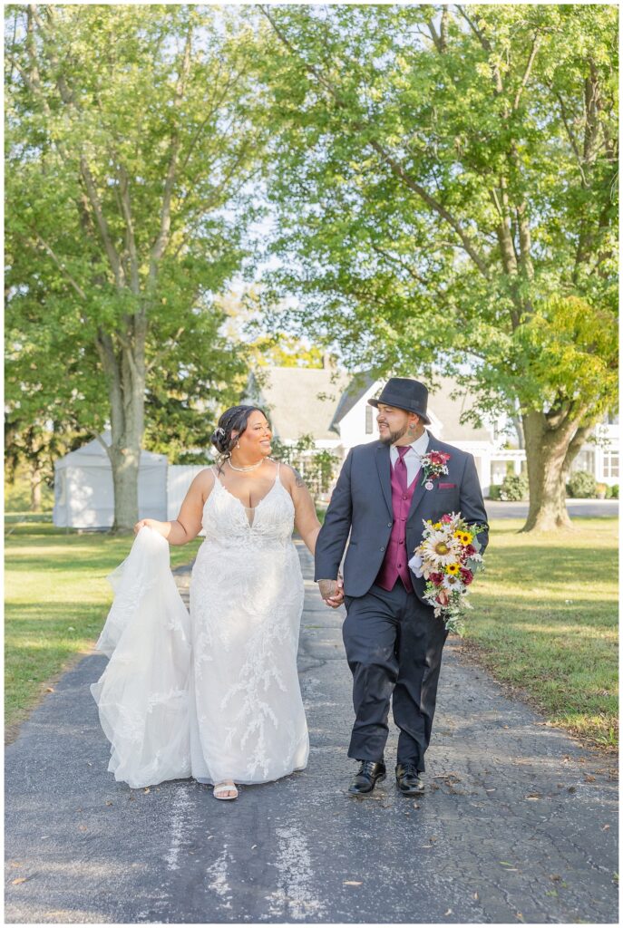 bride and groom holding hands and walking down the driveway of the Christy House venue