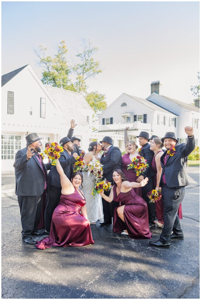 full wedding party cheering outside in front of the Christy House venue