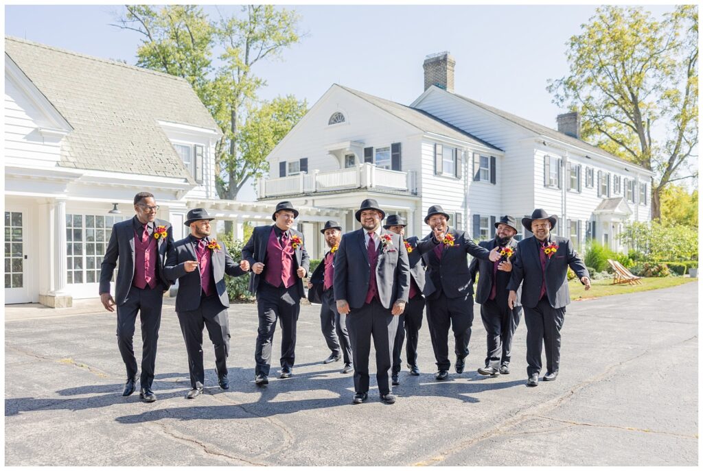 groomsmen walking in a group in front of the Christy House venue in Fremont, Ohio