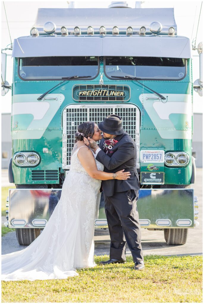 wedding couple sharing a kiss in front of the groom's blue green truck in Fremont, Ohio