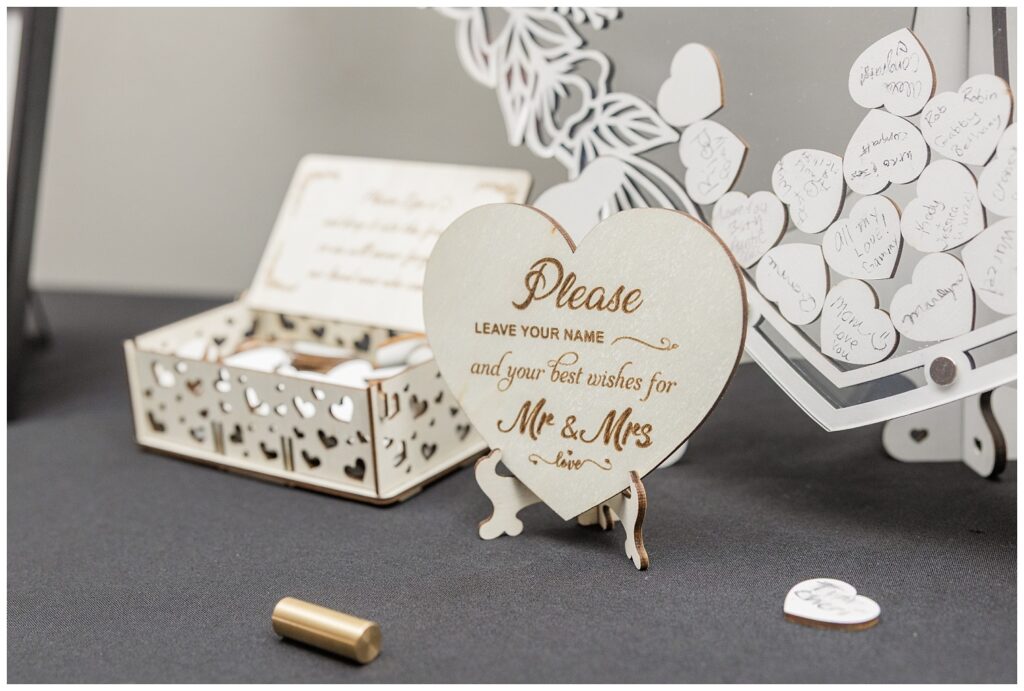 guest book with little wooden hearts for people to sign at the wedding reception