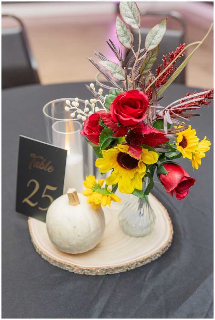 table reception details with pumpkins and flowers at the Victor's Center