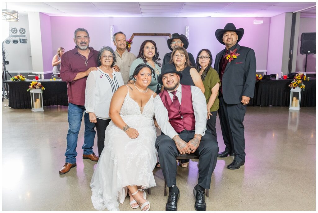 guest portraits with the bride and groom sitting in the middle of the reception room