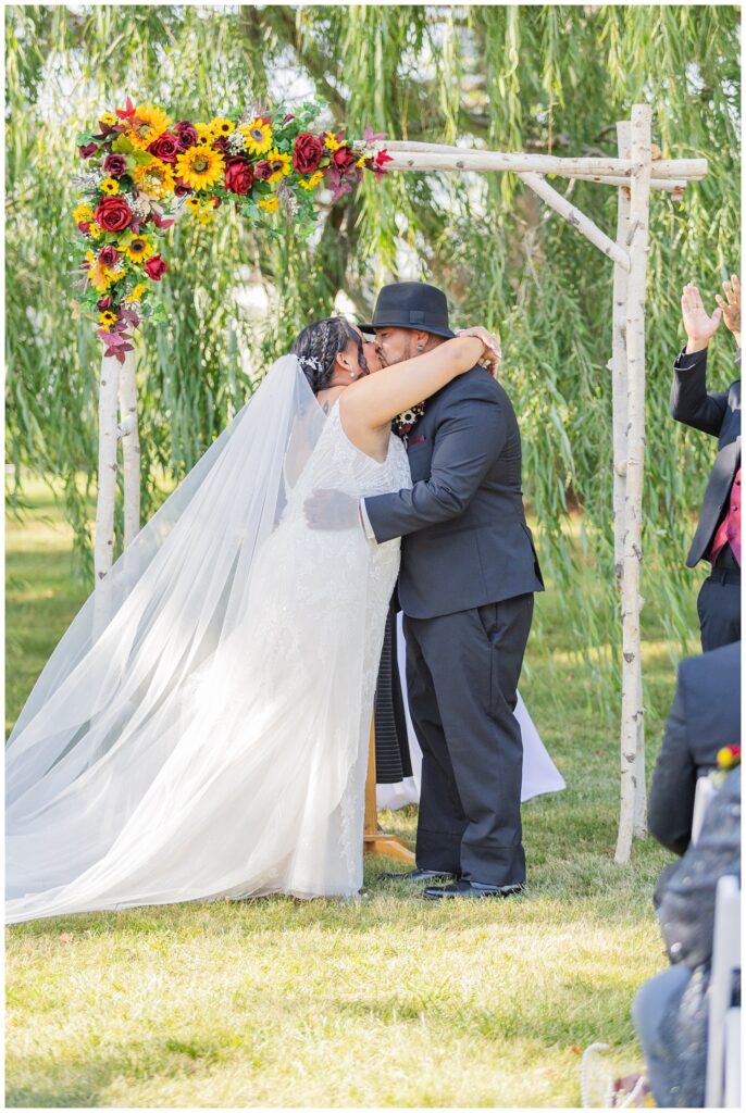 bride and groom share kiss at the end of the outdoor ceremony in northwest Ohio