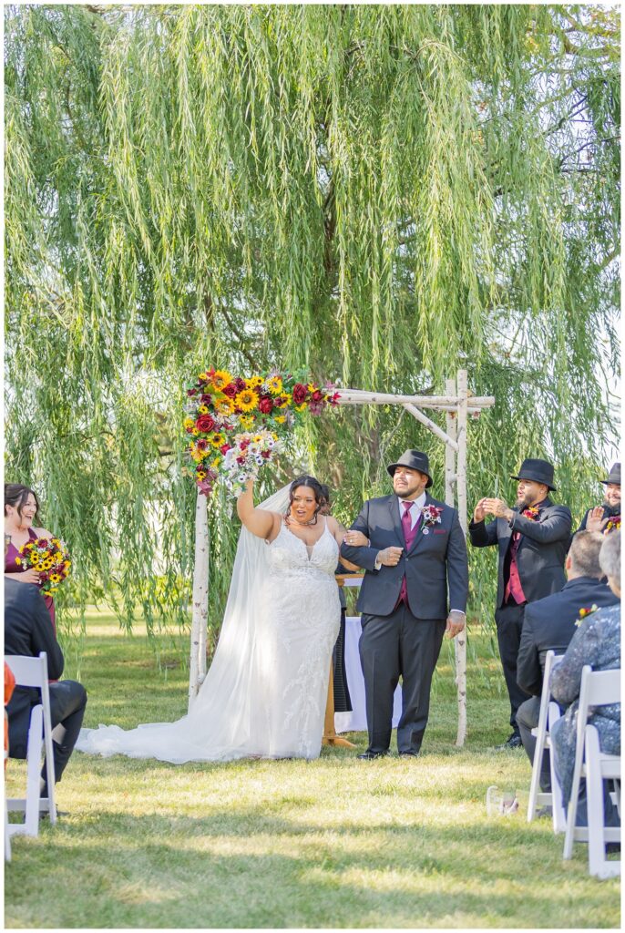 bride and groom cheering at the end of the outdoor ceremony in northwest Ohio