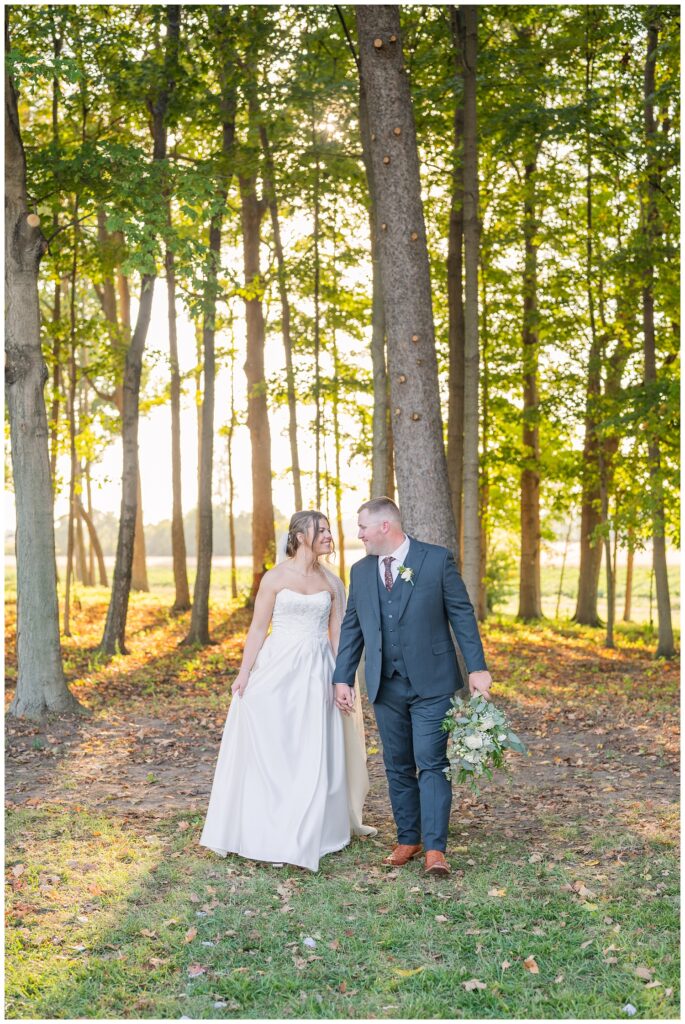 wedding couple holding hands and walking together and smiling at each other