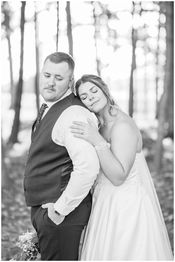 bride resting her head on the groom's with her eyes closed as he looks back at her