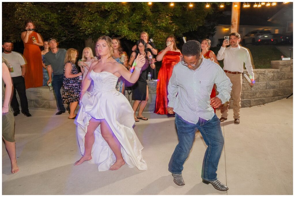 bride dancing outside on the patio with wedding guests during reception