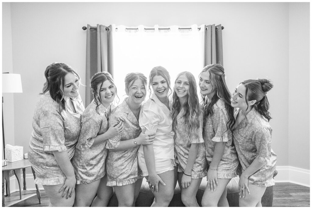bride and bridesmaids dressed in matching silk pajamas posing together in the venue