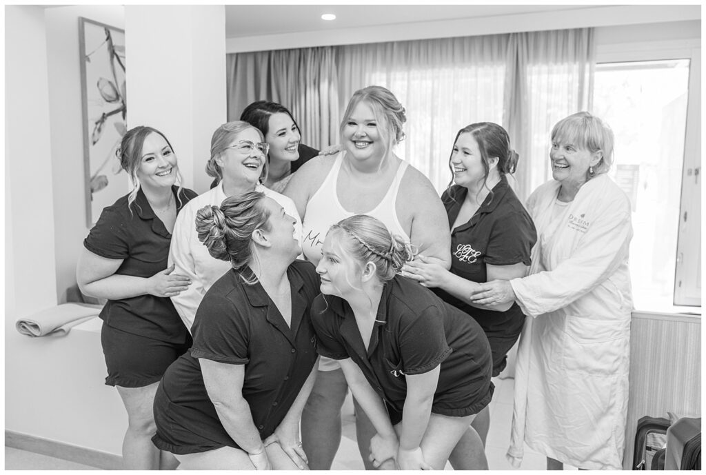 bride posing with her bridesmaids with everyone wearing their pajamas while getting ready