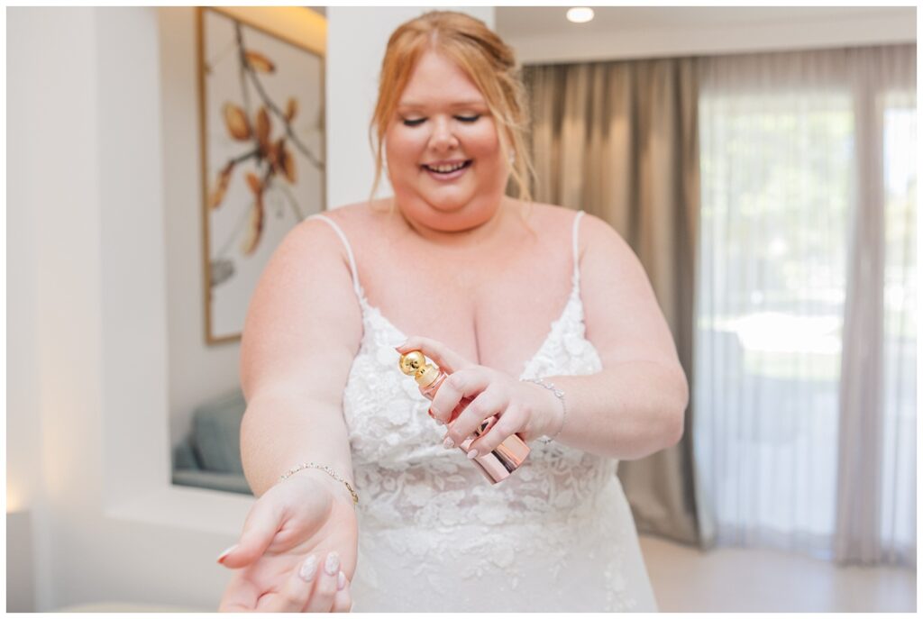 bride spraying her pink perfume on her wrist getting ready for her Punta Cana wedding