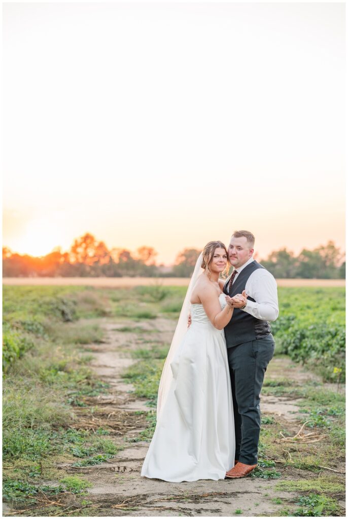 bride and groom posing for sunset portraits during the reception 