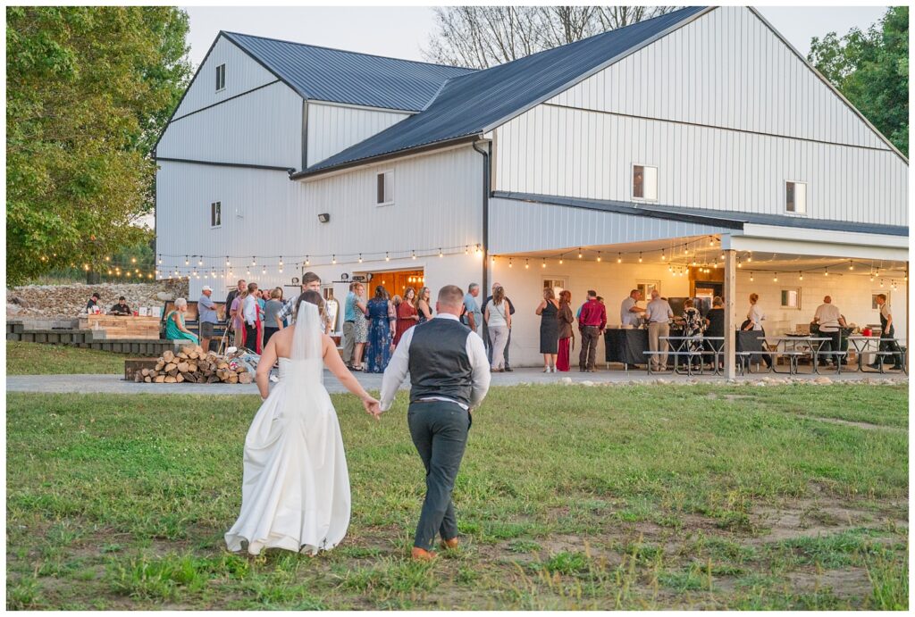 bride and groom holding hands walking back up to the reception venue