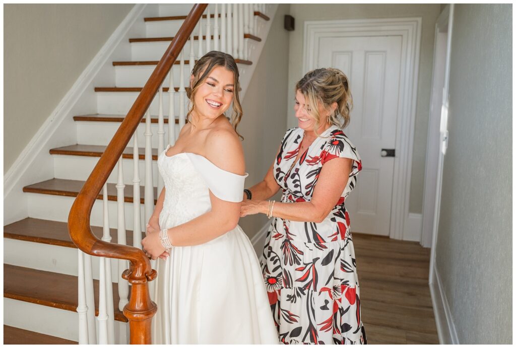 mom zipping the bride in her dress in the foyer of the Octagon House wedding venue