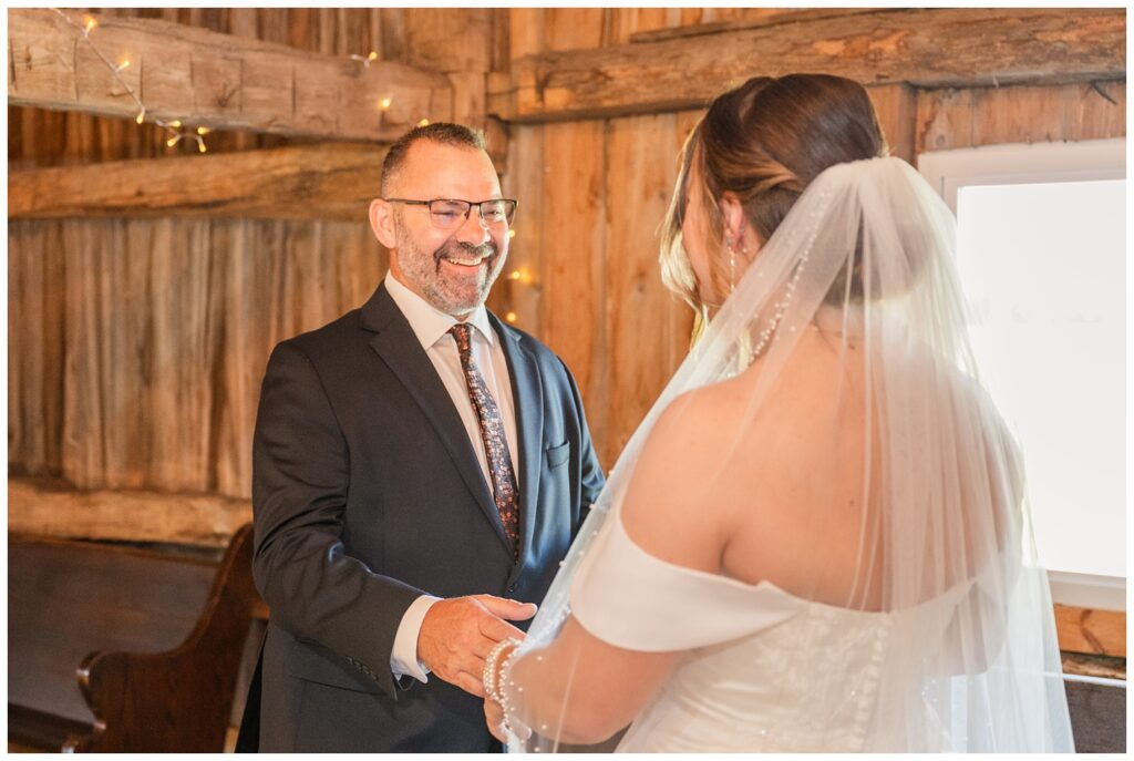 bride having a first look with her dad in the top of the barn