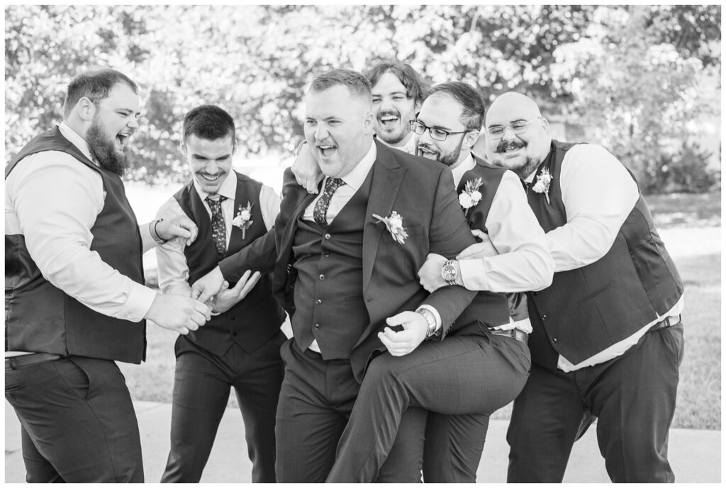 groomsmen having fun with the groom during portraits before the ceremony