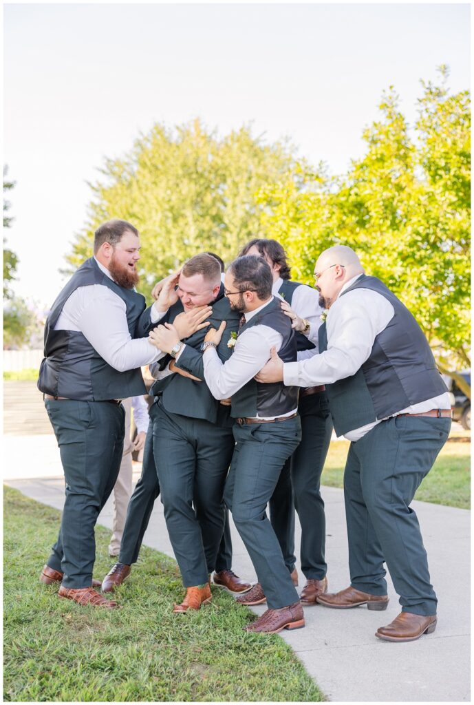 groomsmen having fun with the groom during portraits before the fall ceremony