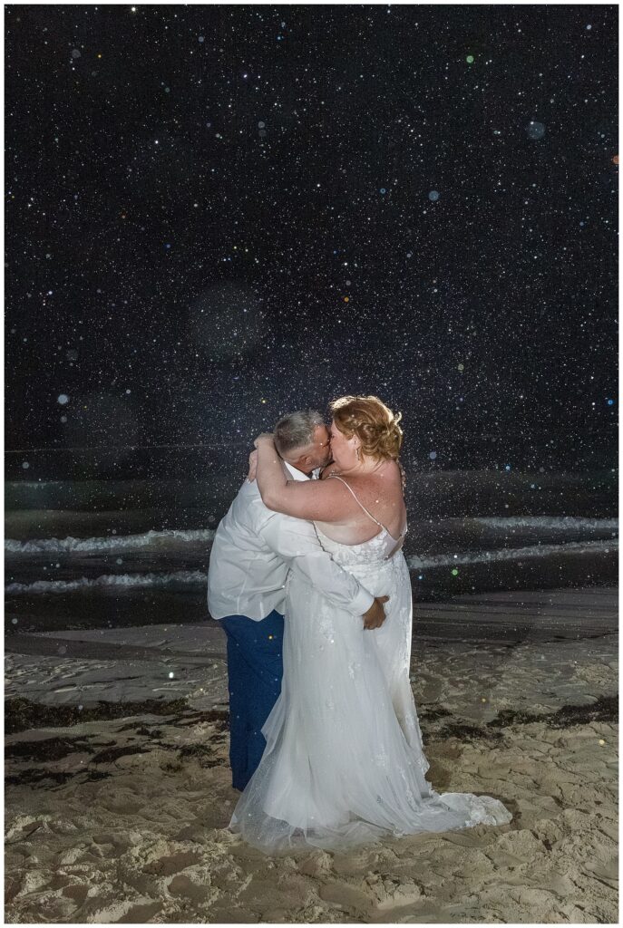 bride and groom kissing at night on the beach after wedding reception in Punta Cana