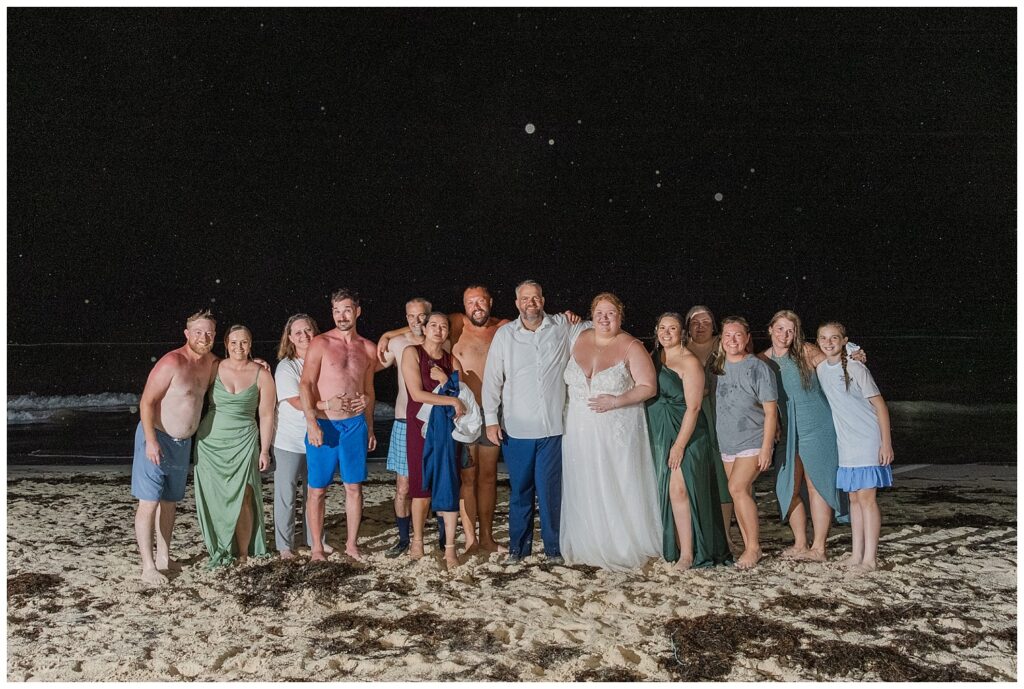 wedding party and friends posing on beach at night after Punta Cana reception