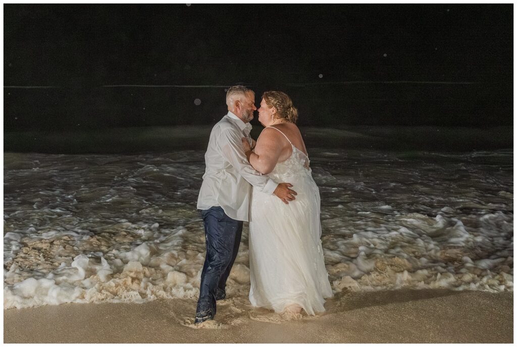 bride and groom hugging on the beach after splashing around in the ocean in Punta Cana