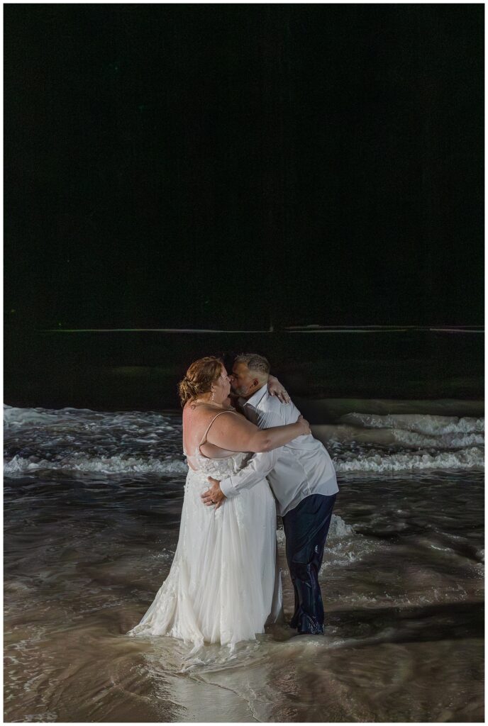 bride and groom kissing on the beach after splashing around in the ocean in Punta Cana