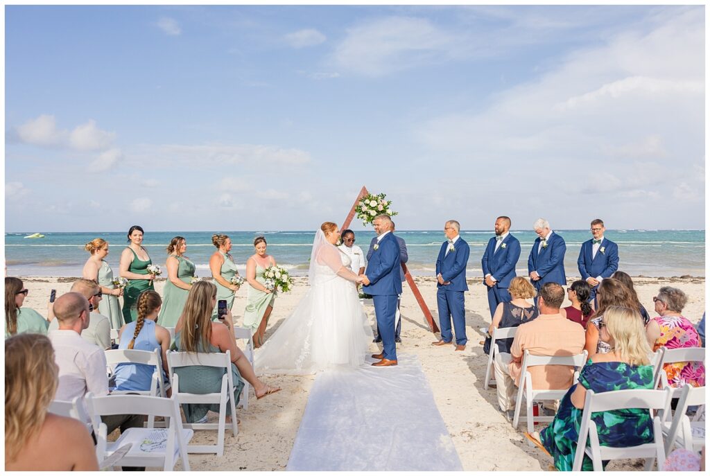 bride and groom holding hands at the altar on the beach at Punta Cana resort wedding