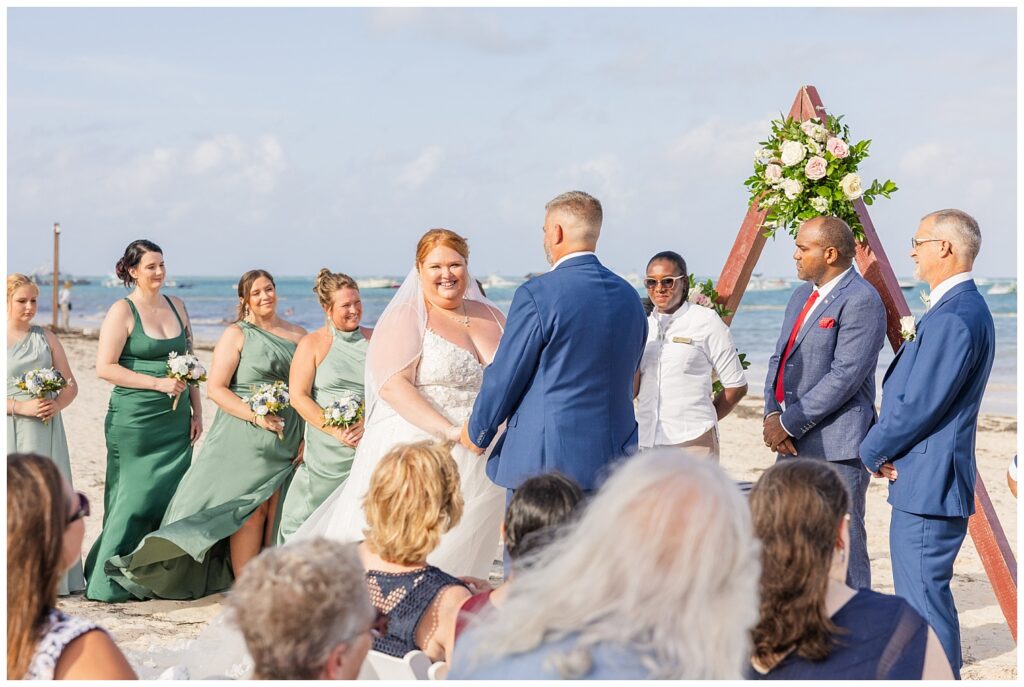 bride and groom holding hands at the altar on the beach at Punta Cana dream resort wedding