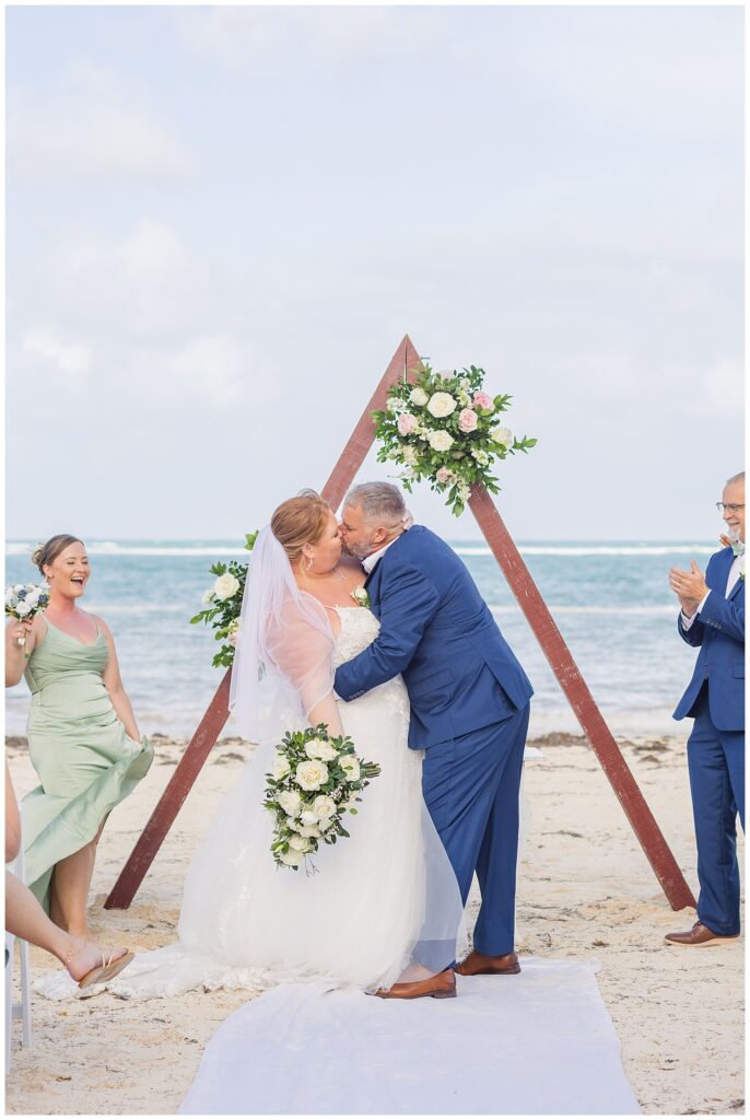 wedding couple kissing at the end of the ceremony on the beach at Punta Cana Dream Resort