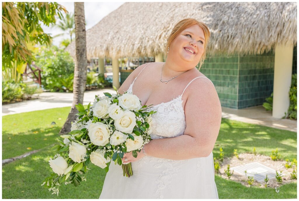 bride looking back and smiling while posing with her bouquet at Punta Cana Dream Resort wedding