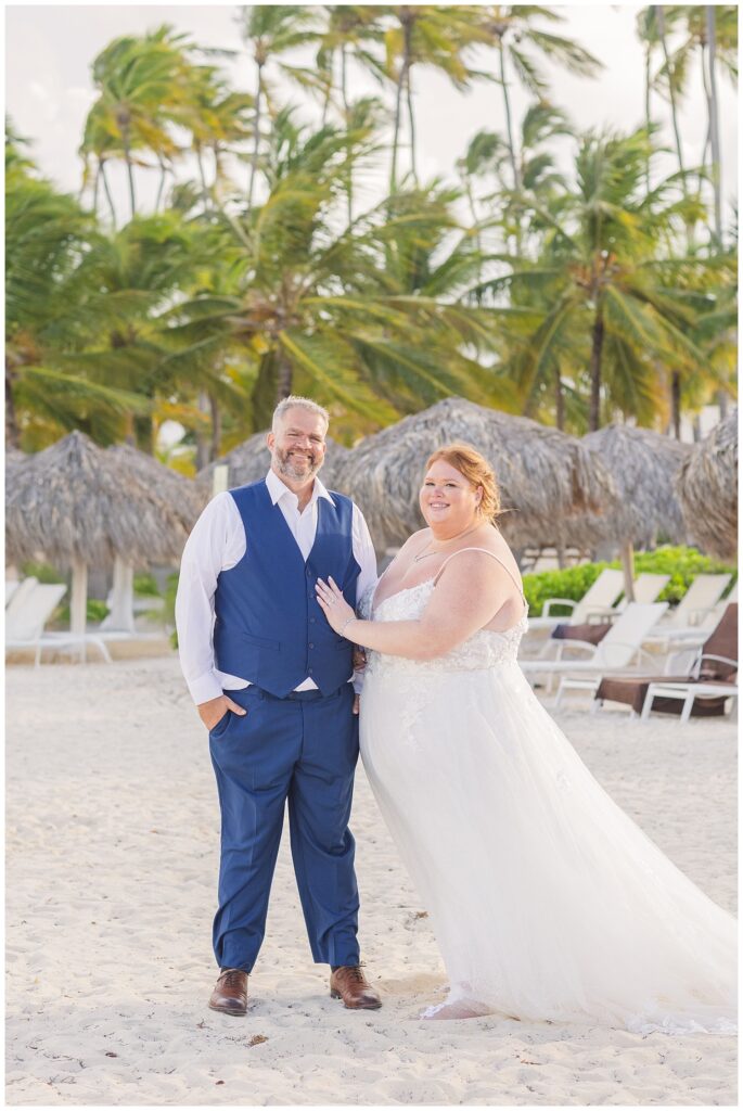 wedding couple posing in front of lounge chairs on the beach at Punta Cana 