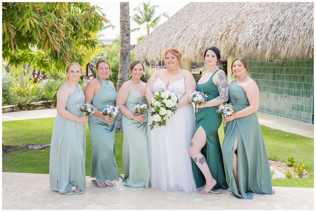 bride posing with her bridesmaids near the pools under the palm trees at Punta Cana wedding