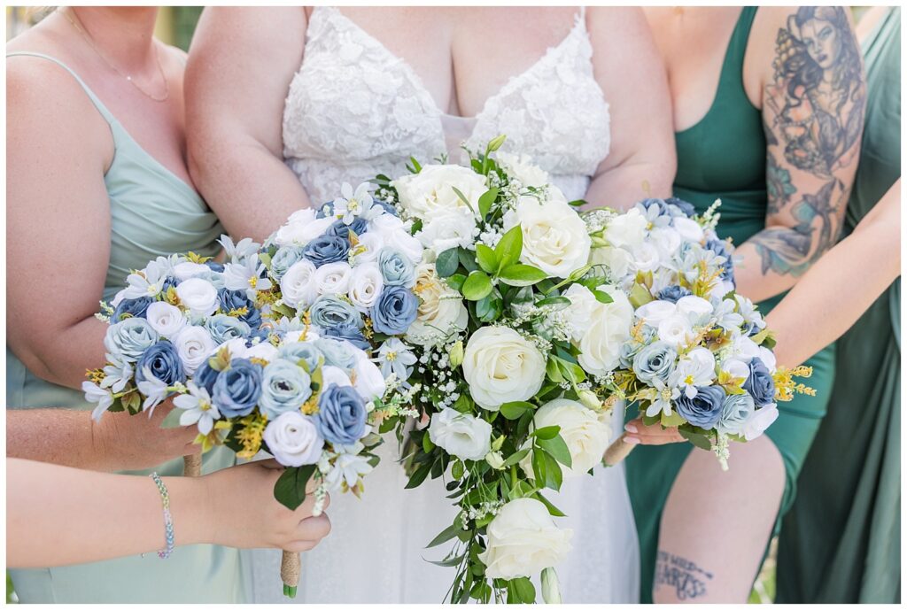 bride and bridesmaids putting their flowers in a group while wearing shades of green
