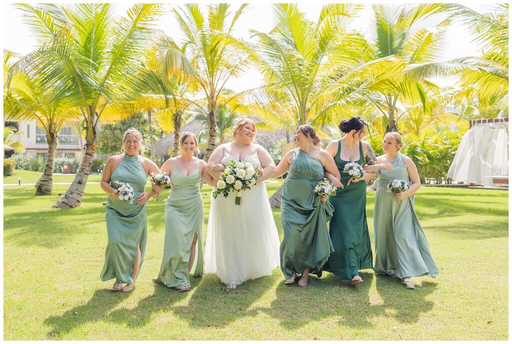bridal party walking and smiling together on the grass at Punta Cana wedding