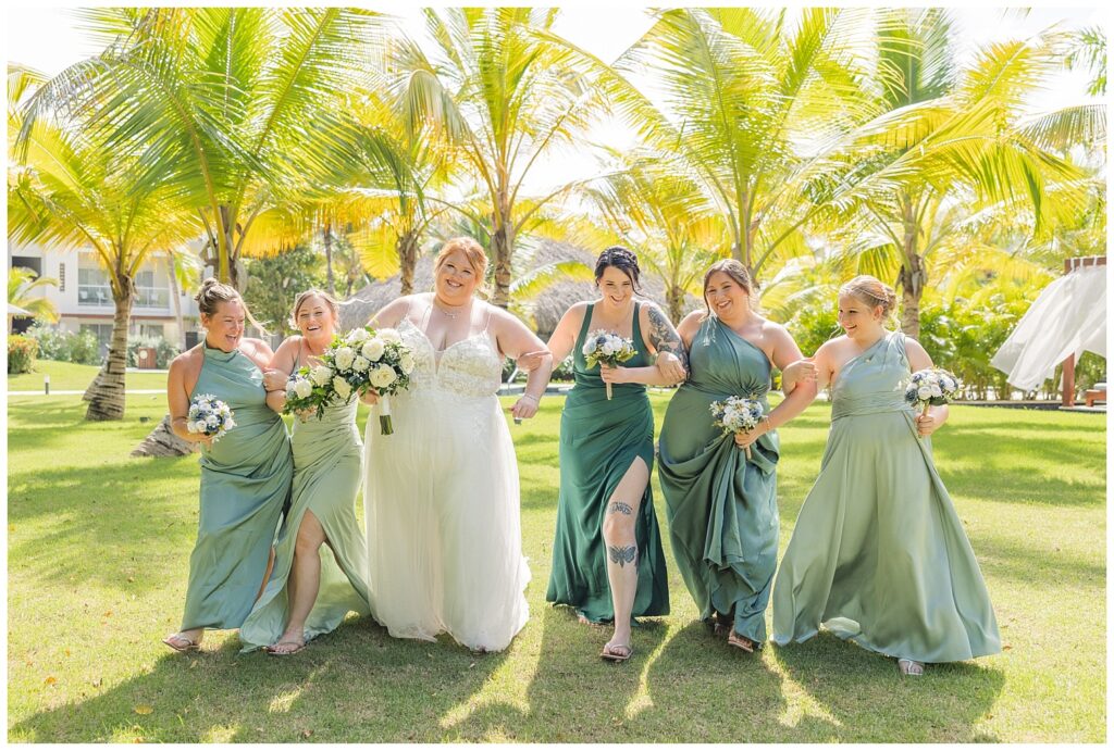 bridal party walking and smiling together on the grass at Punta Cana wedding resort