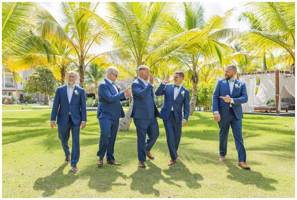 groomsmen walking and smiling together on the grass for Punta Cana resortwedding