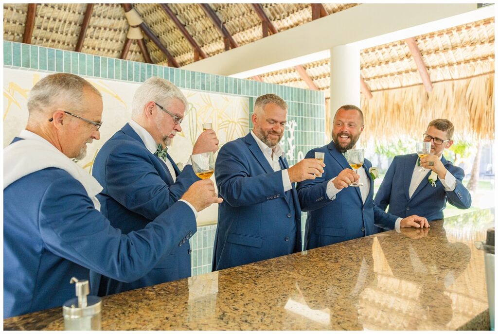 groomsmen toasting at the bar with bourbon before the ceremony starts in Punta Cana