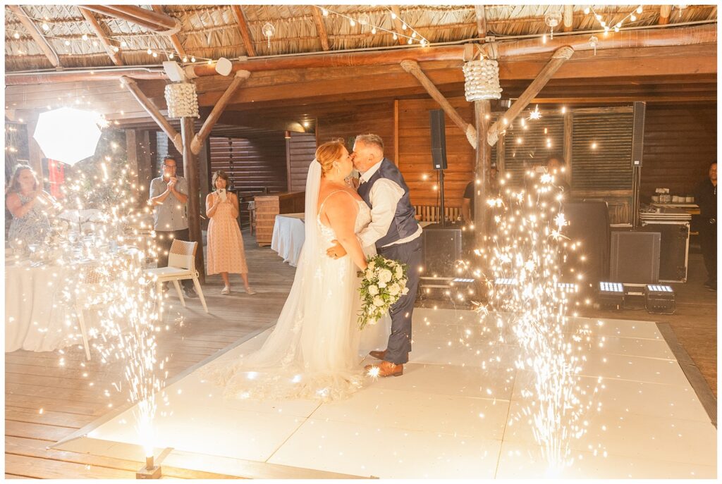 bride and groom kiss on the dance floor surrounded by floor sparklers in Punta Cana