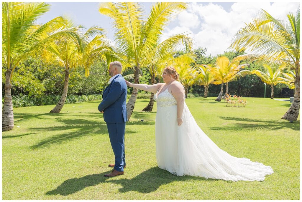first look moment between bride and groom next to palm trees at Punta Cana resort wedding