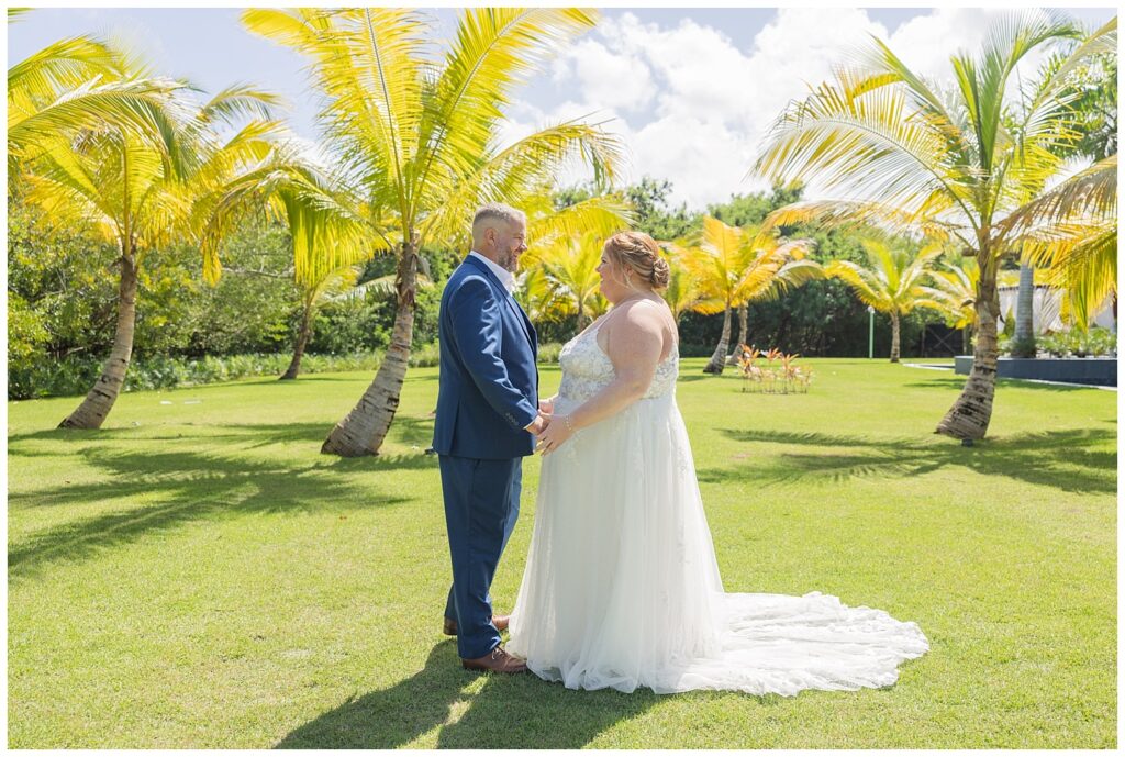 first look moment between bride and groom next to palm trees at Punta Cana resort wedding
