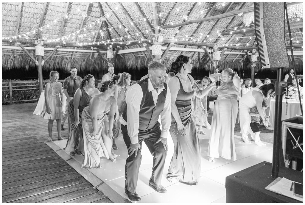 wedding guests and couple dancing together on the floor during reception at Punta Cana Dreams Resort