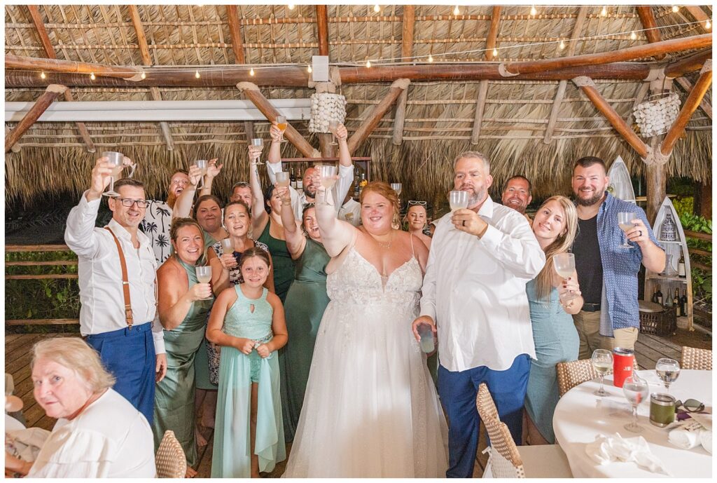 wedding guests and couple cheering with glasses raised during reception at Punta Cana Dreams Resort