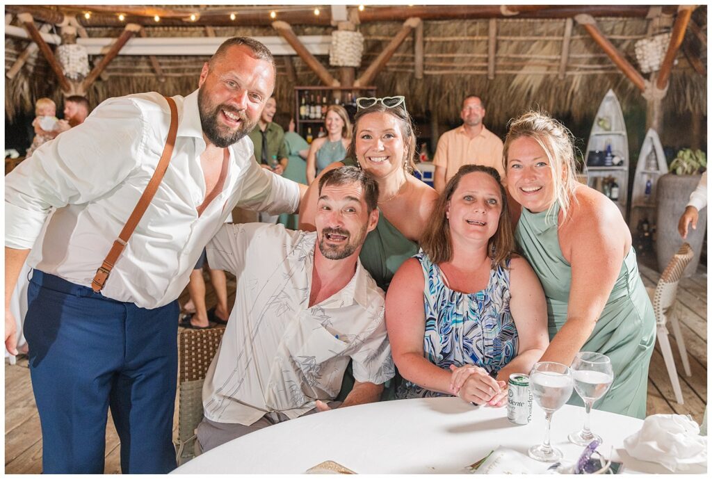wedding guests sitting at a table posing for reception portraits in Punta Cana