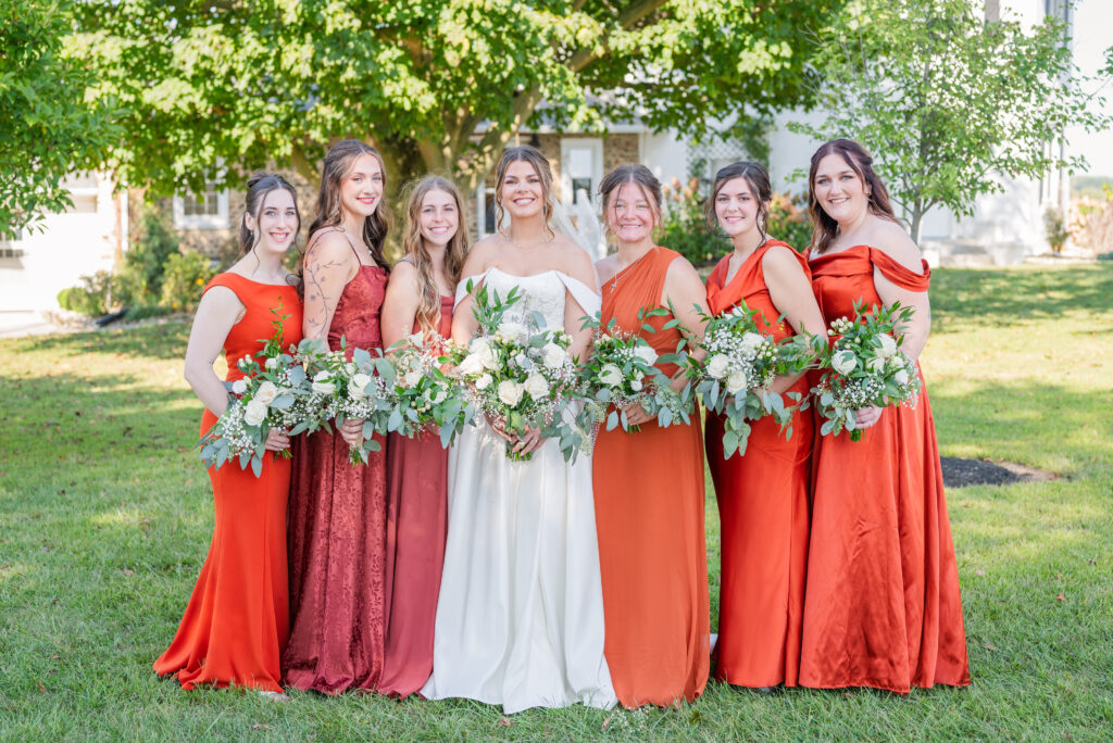 bride posing with her bridesmaids at a Fremont, Ohio wedding venue in the fall