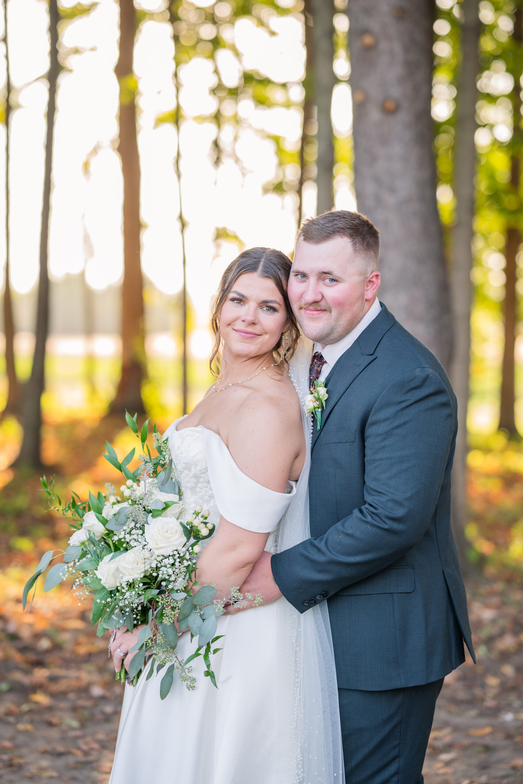 bride and groom posing together among trees during golden hour in Tiffin, Ohio