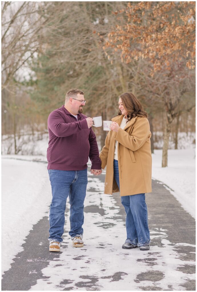 engaged couple holding hands and walking together at the Garlo Heritage Nature Preserve and drinking coffee