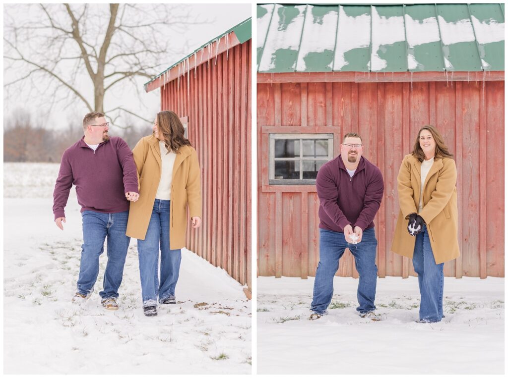 engaged couple holding balls of snow standing in front of a red barn in Ohio