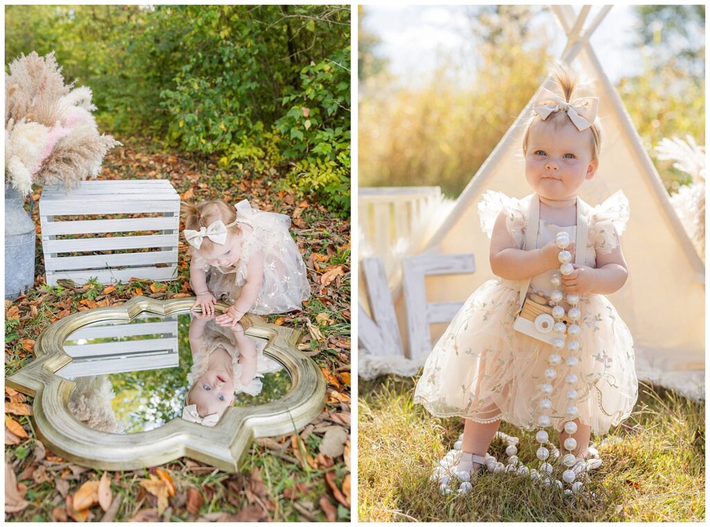 one year old holding a big string of pearls and posing in front of a beige tent