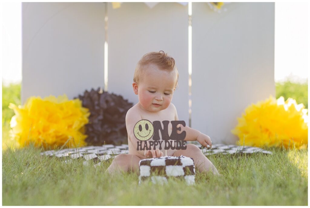 one year old boy sitting on a black and white blanket at Tiffin, Ohio cake smash session