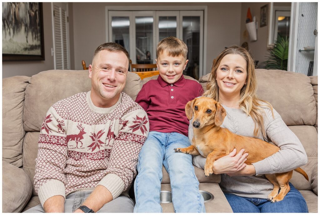 family sitting on the couch with their dog for portrait session in Fremont, OH